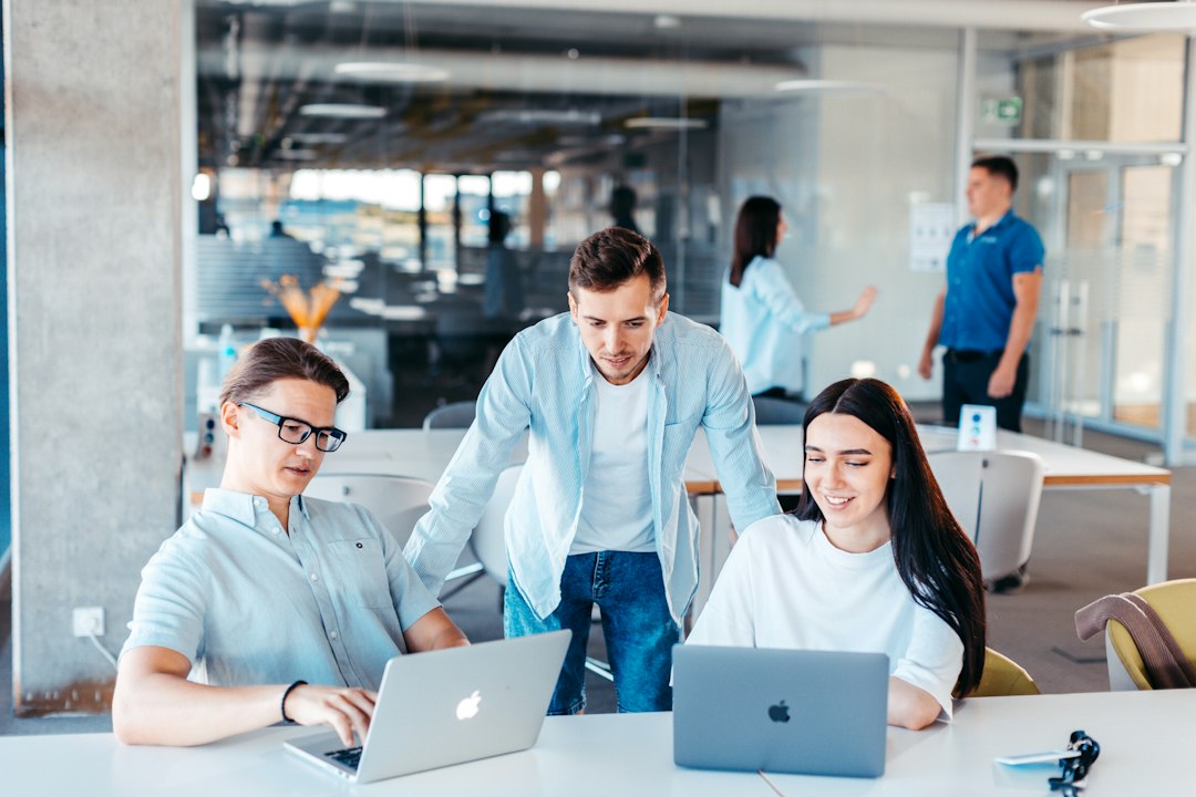 Professionals collaborating around laptops during a software project meeting